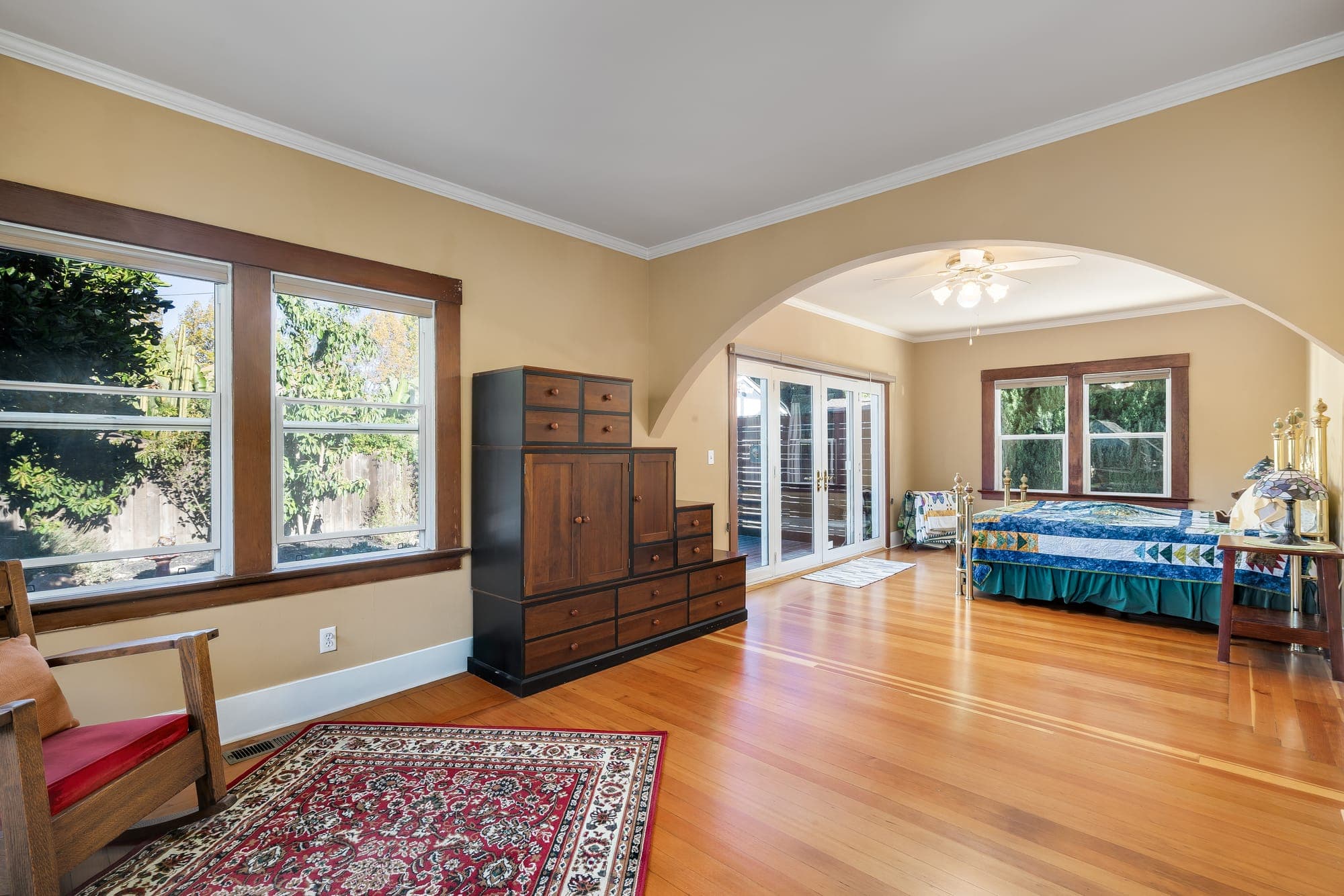 A sitting area beneath an arched opening to the bedroom beyond.
