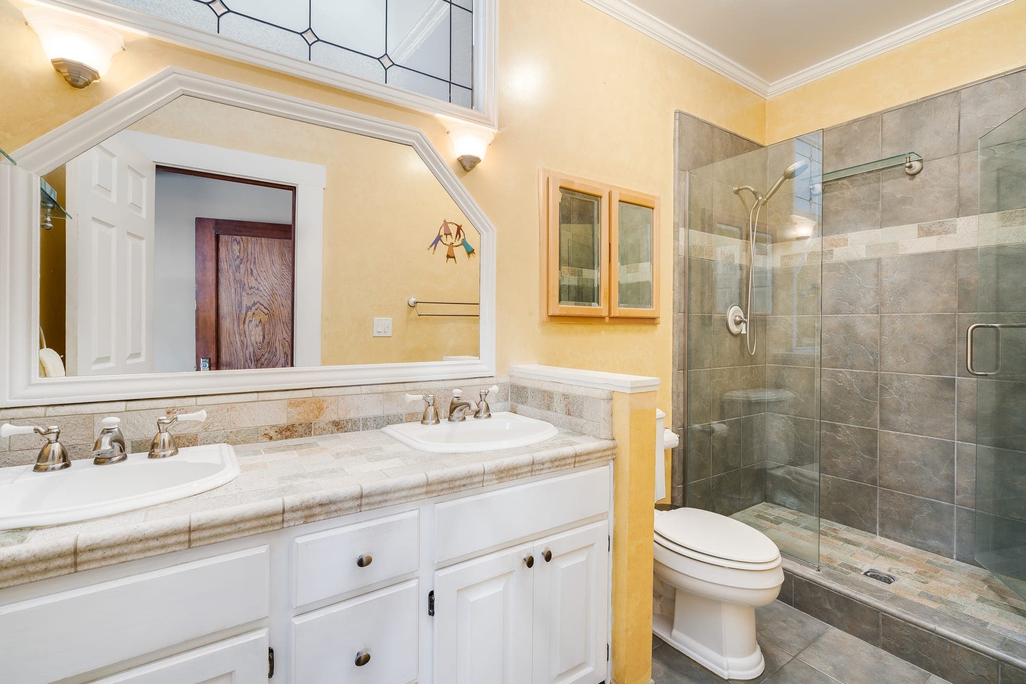 A bathroom with a double vanity and a glass-walled shower.