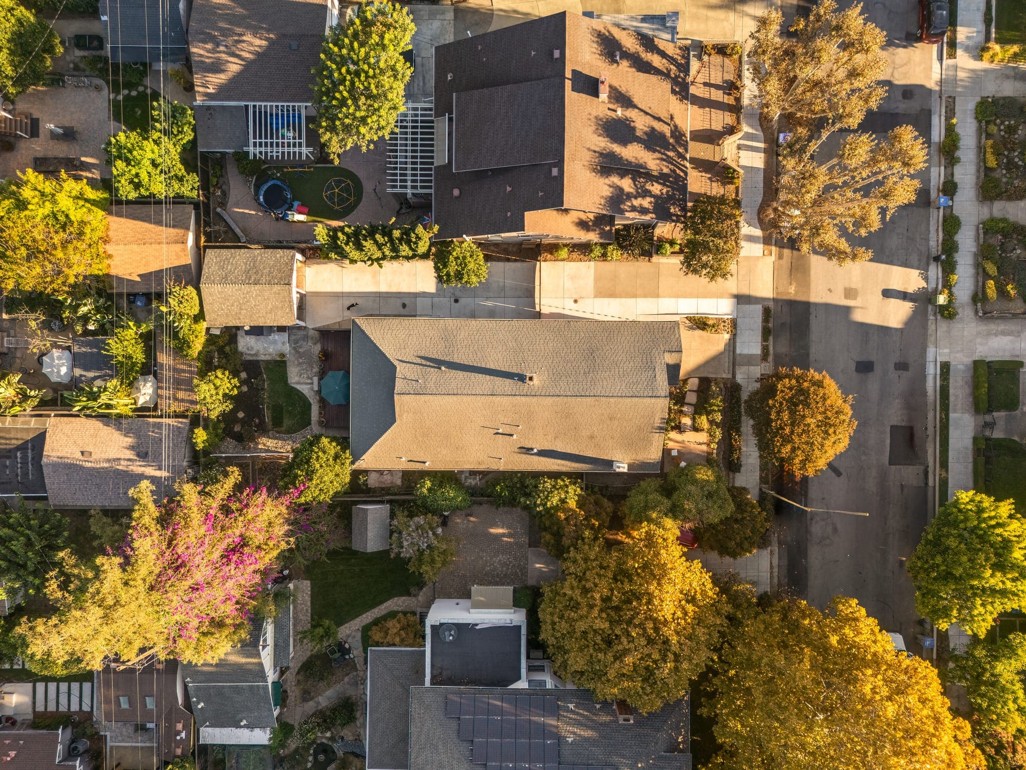 Overhead aerial view of the home and its lot among the neighborhood's trees.