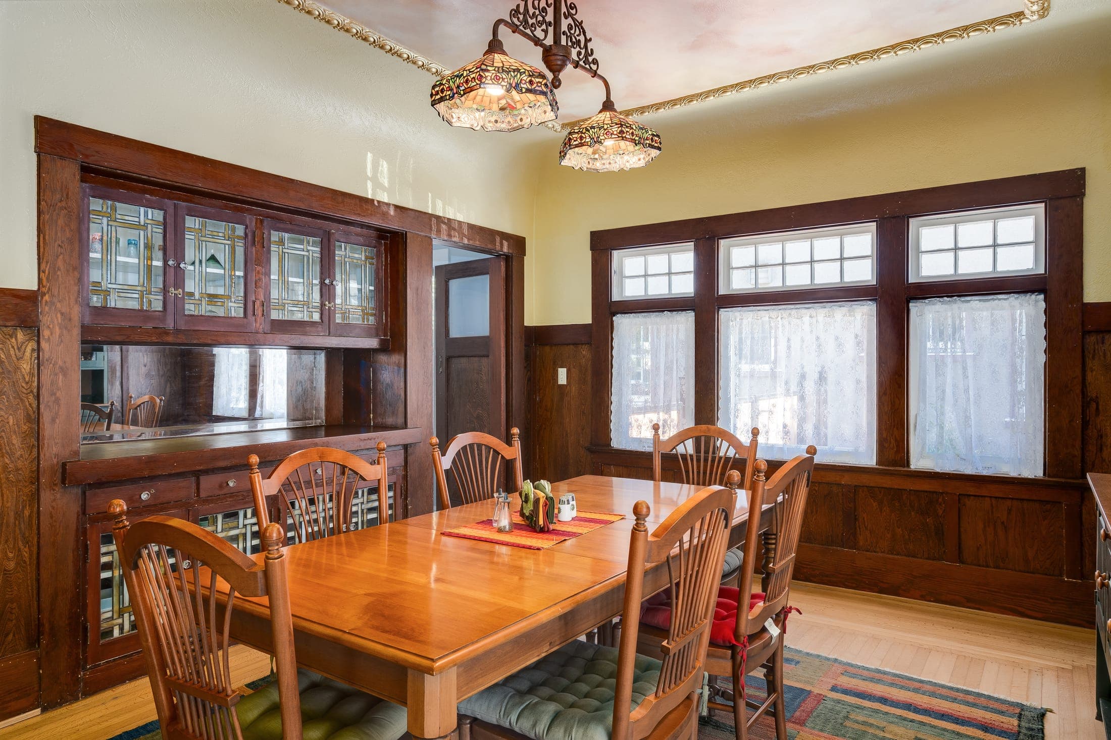 The dining room's built-in buffet, leaded glass, and wood wainscoting.